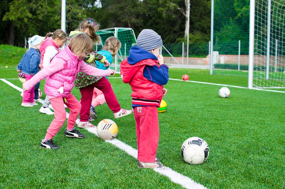 Kids shooting soccer balls into a goal during practice