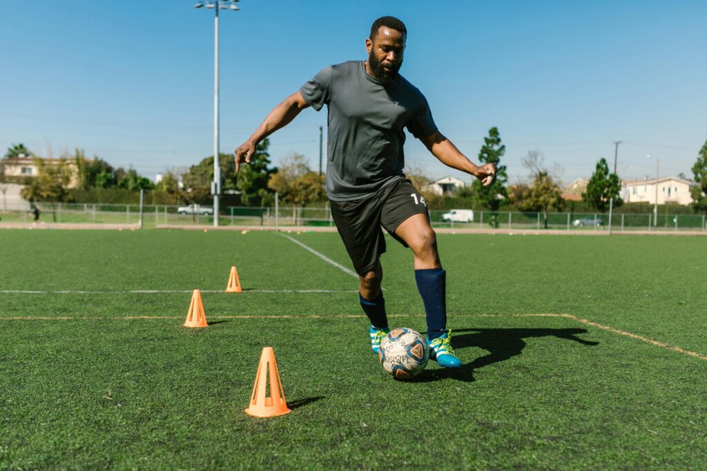 Soccer player practicing dribbling skills with cones in solo soccer training